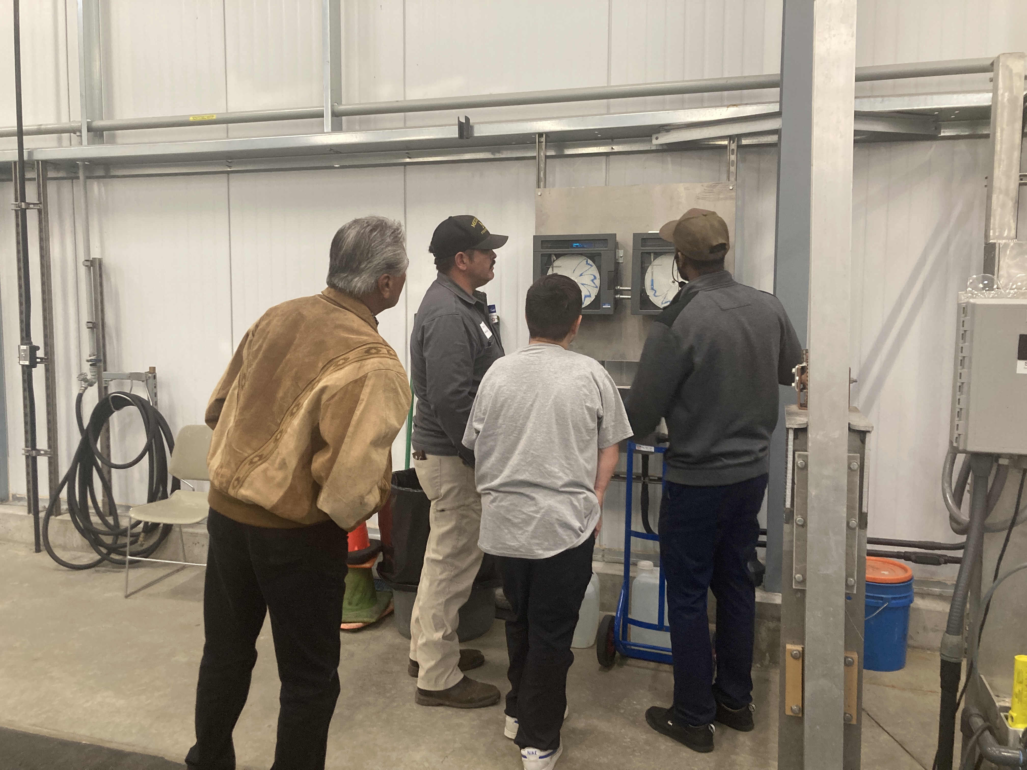 Four males looking at a wastewater use tracking device